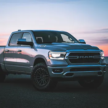 Pickup truck parked at sunset on open road.